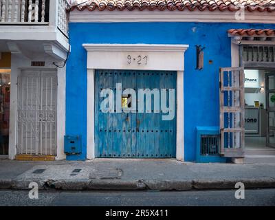 Cartagena, Provinz Cartagena, Bolivar, Kolumbien - Februar 16 2023: Blaues Haus mit blauer Holztür mit weißem Rahmen und mehreren Schlössern Stockfoto