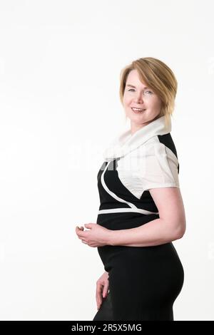 Lächelnde selbstbewusste, stilvolle, Erwachsene Geschäftsfrau, die auf weißem Hintergrund auf die Kamera schaut. Geschäftsperson für ethnische Zugehörigkeit in Kaukasien Stockfoto