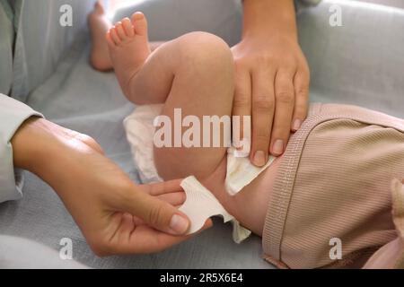 Mutter, die die Windel des Babys wechselt, auf dem Tisch, Nahaufnahme Stockfoto