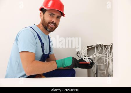 Elektriker mit schraubendrehbarem Patchpanel im Innenbereich Stockfoto