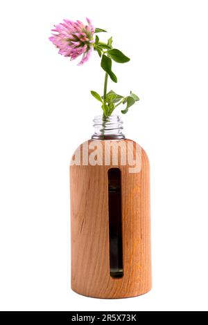 Flasche ätherisches Öl und Kleeblumen auf weißem Hintergrund Stockfoto