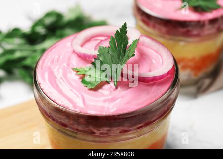 Hering unter Pelzmantel Salat in Glasschale, Nahaufnahme. Traditionelles russisches Gericht Stockfoto