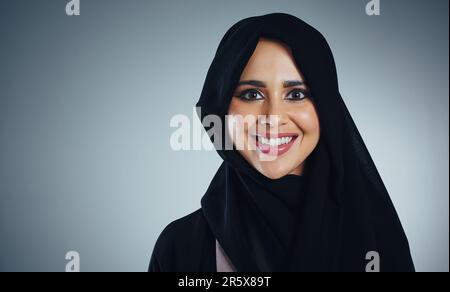 Mein Hidschab, meine Identität. Studioporträt einer jungen muslimischen Geschäftsfrau vor grauem Hintergrund. Stockfoto