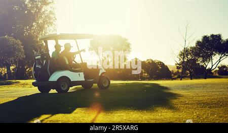 Ich war beim Golfen. Zwei Golfer, die in einem Wagen auf einem Golfplatz reiten. Stockfoto