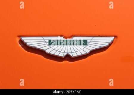 Aston-Martin-Emblem auf einem Sportwagen aus dem Jahr DB9 in der klassischen, blau-orangefarbenen Rennlivette Gulf Oils, Mai 2023. Stockfoto