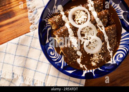 Enchiladas de Mole. Auch bekannt als Mole poblano enchiladas, sind sie ein typisches mexikanisches Gericht, das in Mexiko und dem Rest der Welt sehr beliebt ist. Stockfoto