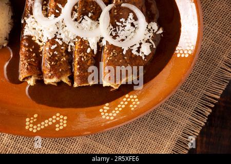 Enchiladas de Mole. Auch bekannt als Mole poblano enchiladas, sind sie ein typisches mexikanisches Gericht, das in Mexiko und dem Rest der Welt sehr beliebt ist. Stockfoto