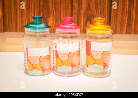 Bunte Glasbecher mit Deckel eignen sich perfekt zum Aufbewahren und Organisieren einer Vielzahl von Gegenständen. Mit ihren leuchtenden Farbtönen und ihrem praktischen Design bieten sie Stockfoto