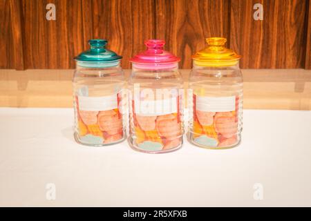Bunte Glasbecher mit Deckel eignen sich perfekt zum Aufbewahren und Organisieren einer Vielzahl von Gegenständen. Mit ihren leuchtenden Farbtönen und ihrem praktischen Design bieten sie Stockfoto