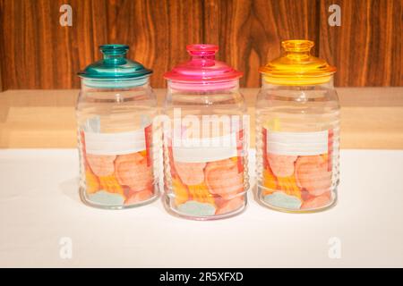 Bunte Glasbecher mit Deckel eignen sich perfekt zum Aufbewahren und Organisieren einer Vielzahl von Gegenständen. Mit ihren leuchtenden Farbtönen und ihrem praktischen Design bieten sie Stockfoto