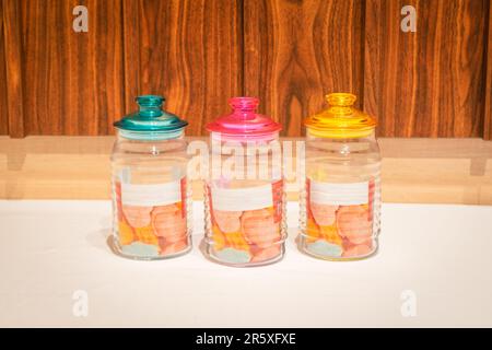 Bunte Glasbecher mit Deckel eignen sich perfekt zum Aufbewahren und Organisieren einer Vielzahl von Gegenständen. Mit ihren leuchtenden Farbtönen und ihrem praktischen Design bieten sie Stockfoto