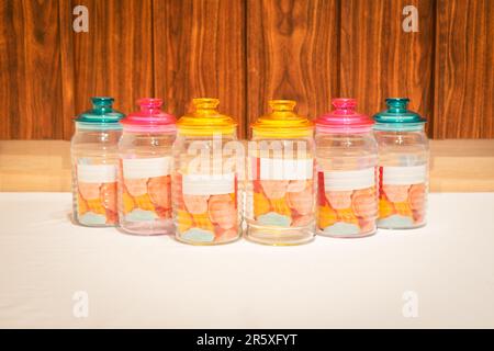 Bunte Glasbecher mit Deckel eignen sich perfekt zum Aufbewahren und Organisieren einer Vielzahl von Gegenständen. Mit ihren leuchtenden Farbtönen und ihrem praktischen Design bieten sie Stockfoto