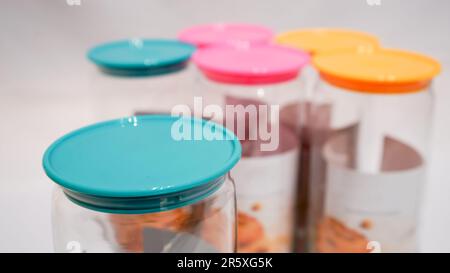 Die farbenfrohen Becher mit Deckel sind die perfekte Aufbewahrungslösung für alle, die ihrem Zuhause einen Hauch von Spaß und Stil verleihen möchten. Diese Gläser haben einen farbenfrohen Deckel Stockfoto