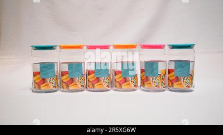 Die farbenfrohen Becher mit Deckel sind die perfekte Aufbewahrungslösung für alle, die ihrem Zuhause einen Hauch von Spaß und Stil verleihen möchten. Diese Gläser haben einen farbenfrohen Deckel Stockfoto
