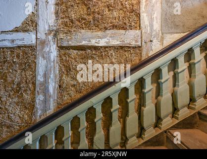 Greiffenberg, Deutschland. 25. Mai 2023. Die Treppe des alten Postamts ist mit Schlammwänden und Halbholzmöbeln ausgestattet. Andere würden dankenswerterweise ablehnen, aber ein Paar aus Berlin hat sich der Herausforderung gestellt: Sie retten ein historisches, fast 300 Jahre altes Denkmal in der Provinz Uckermark vor weiterer Verwesung und schaffen einen neuen Treffpunkt für das Dorf. (An dpa: "Uckermärkische Geschichten in der alten Post") Kredit: Patrick Pleul/dpa/Alamy Live News Stockfoto