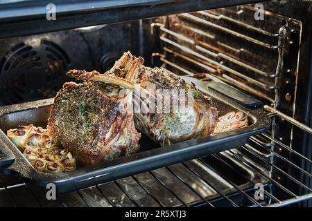 Lammrippchen mit Knoblauch und Sauce, die im Ofen gebacken wurden Stockfoto