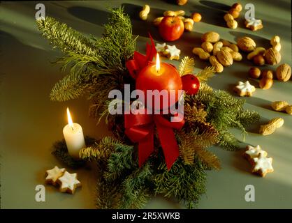 Brennende Kerzen, Weihnachtsblumen-Arrangement, Nüsse und Zimtsterne, Lebkuchen, Weihnachtszeit, Advent, brennende Kerzen, Weihnachtsblume Stockfoto