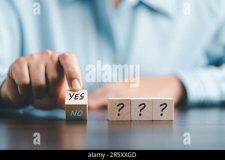 Konzept der Wahl Ja bei Holzkubikblöcken. Mit Ja oder Nein denken, Geschäftsentscheidungen in schwierigen Situationen, Geschäftsfrau mit Holzhänden Stockfoto