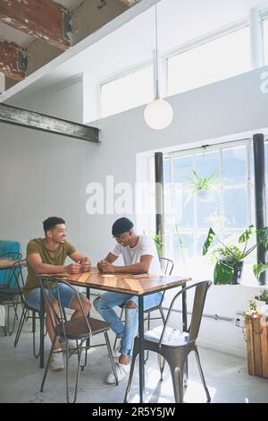 Waren Brüder mehr als Freunde. Ein Foto von zwei gutaussehenden Freunden, die sich tagsüber in einem Coffeeshop versammeln. Stockfoto