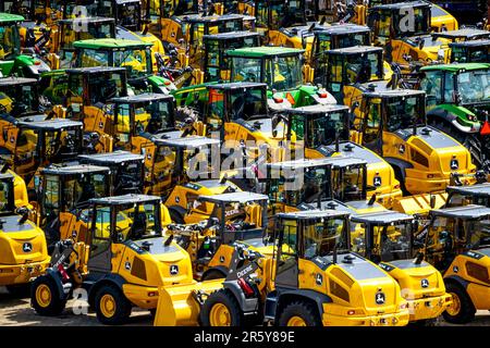 Bremerhaven, Deutschland. 26. April 2023. Traktoren und Baumaschinen des Herstellers John Deere befinden sich auf dem Gelände von BLG Autoterminal Bremerhaven. Kredit: Sina Schuldt/dpa/Alamy Live News Stockfoto