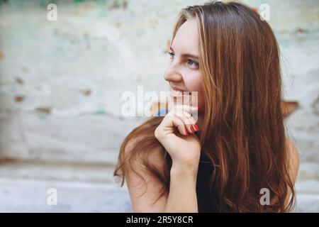 Ich kann mir keine bessere Möglichkeit vorstellen, meinen Tag zu verbringen. Eine junge Frau, die draußen sitzt, während sie eine fremde Stadt erkundet. Stockfoto