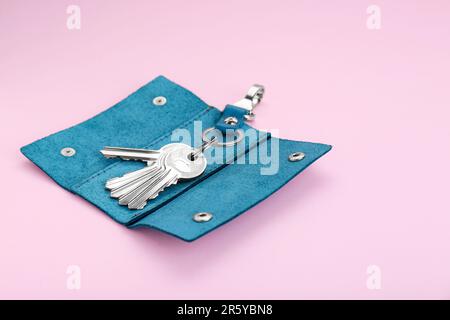 Eleganter Lederhalter mit Schlüsseln auf pinkfarbenem Hintergrund Stockfoto