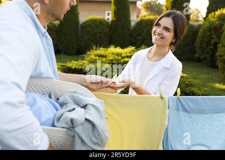 Familienbekleidung mit Wäscheklammern an der Wäscheleine zum Trocknen im Garten Stockfoto