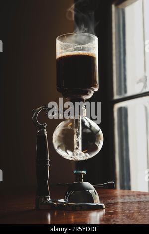 Vakuumkaffeemaschine auf Holztisch im Café Stockfoto