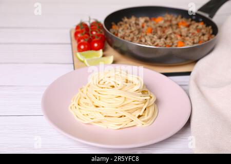 Köstliche Spaghetti, Hackfleisch und Tomaten auf einem weißen Holztisch Stockfoto