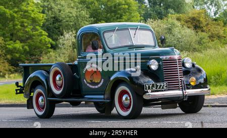 Stony Stratford, Großbritannien - 4. 2023. Juni: 1940 Uhr grüner CHEVROLET holt ein klassisches Auto ab, das auf einer englischen Landstraße fährt. Stockfoto