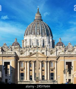 Fassade der berühmten päpstlichen Basilika (auch bekannt als Petersdom) unter blauem Himmel im Vatikan. Stockfoto