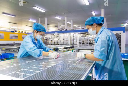 HAIAN, CHINA - 6. JUNI 2023 - Arbeiter stellen Solarmodule für den Export auf der Produktionslinie einer neuen Energiewerkstatt in Haian, Jiangsu, her Stockfoto