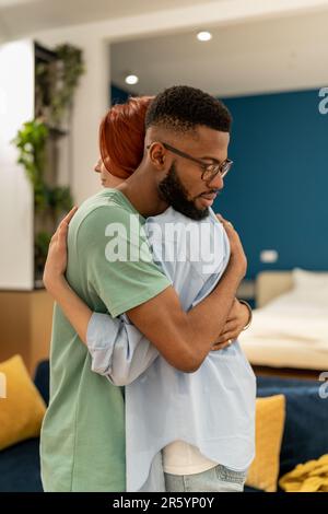 Liebevoller, unterstützender Ehemann, der seine Frau zu Hause sanft umarmt. Liebe und Unterstützung in Beziehungen Stockfoto