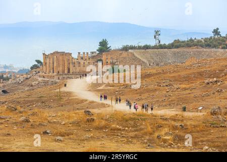 Jerash, Jordanien - 7. November 2022: Besucher des Zeus-Tempels und des Amphitheaters in der antiken römischen Siedlung Gerasa Stockfoto