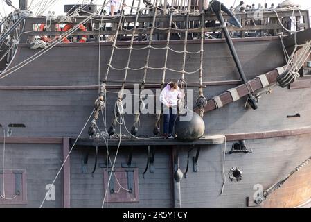 Nachbildung der spanischen Galeone aus dem 17. Jahrhundert am Southend Pier, Southend on Sea, Essex, Großbritannien. Weibliches Besatzungsmitglied mit angehobener Kugelabdeckung an der Seite des Schiffs. Skalieren Stockfoto