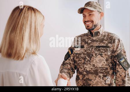 Psychologe schüttelt sich die Hand mit einem Offizier im Amt Stockfoto