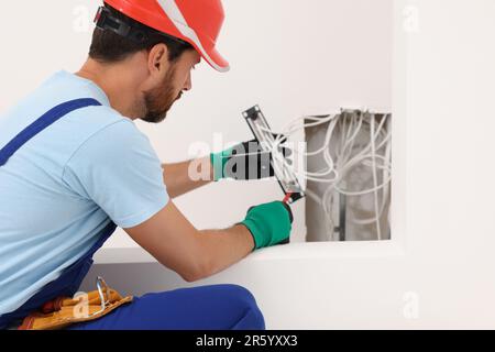 Elektriker mit schraubendrehbarem Patchpanel im Innenbereich Stockfoto