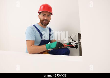 Elektriker mit schraubendrehbarem Patchpanel im Innenbereich Stockfoto