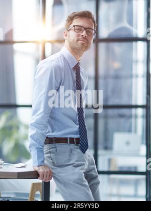 Junger, fröhlicher Geschäftsmann, der im Büro arbeitet Stockfoto