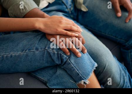 Nahaufnahme eines jungen birassischen Paares in legerer Kleidung, das zu Hause auf dem Sofa sitzt Stockfoto