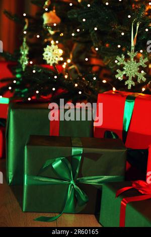 Wunderschön verpackte Geschenkboxen unter dem Weihnachtsbaum drinnen Stockfoto