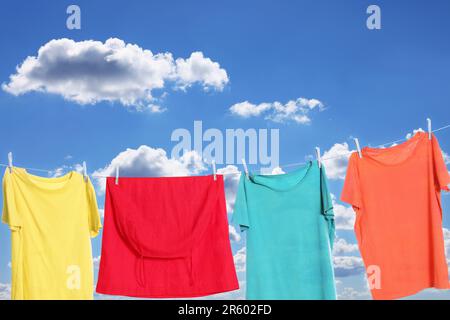 Verschiedene Kleidungsstücke trocknen an der Wäscheleine gegen den Himmel Stockfoto