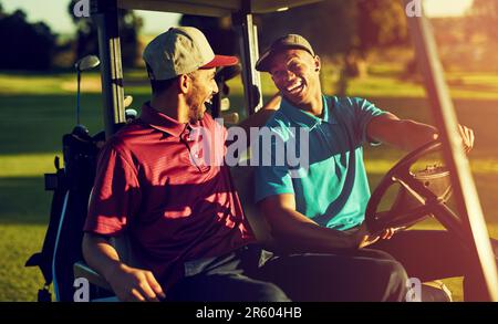 Clubbing vom Feinsten. Zwei Golfer, die in einem Wagen auf einem Golfplatz reiten. Stockfoto