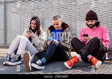 Freunde, die mit dem Telefon durch soziale Medien scrollen Stockfoto