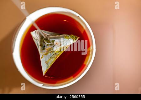 Nehmen Sie einen Beutel grünen Tee aus einem Einwegglas mit gebrühtem grünen Tee. Ein Imbiss Stockfoto