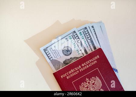 Russischer ausländischer Pass, in dem Dollar oder Euro für die Reise zur Grenze sind. Konzept für Urlaub, Migration oder Reisen. Stockfoto