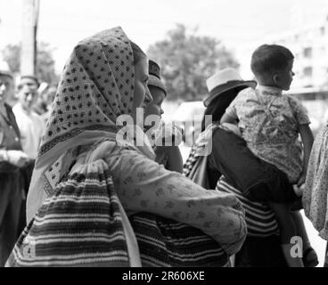 Maramures County, Rumänien, ca. 1980. Familie in traditioneller Volkskleidung in einer Stadtstraße. Stockfoto