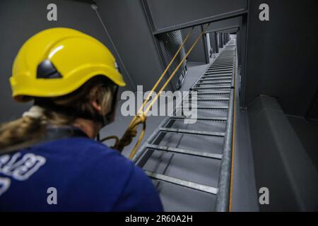 06. Juni 2023, Sachsen-Anhalt, Halle (Saale): Feuerwehrmann Brooke Mollenkamp aus den USA steht während einer Übung des Höhenrettungsteams der Feuerwehr Halle auf einem Brückenpylon der Berliner Brücke. Die Feuerwehr hat derzeit einen Besucher aus der US-amerikanischen Zwillingsstadt Savannah: Feuerwehrmann Mollenkamp erfährt etwas über die Arbeit der deutschen Feuerwehr. Vor ihrem Besuch in Halle war eine Feuerwehrfrau aus Halle drei Wochen lang in Savannah im Bundesstaat Georgia im Südosten der USA. Foto: Jan Woitas/dpa/zB Stockfoto