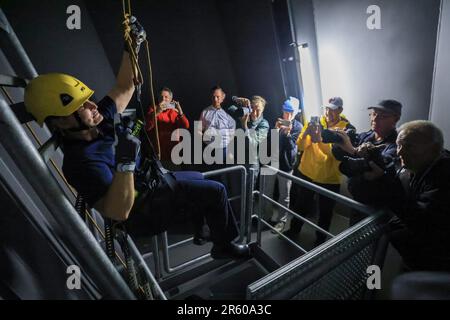 06. Juni 2023, Sachsen-Anhalt, Halle (Saale): Feuerwehrmann Brooke Mollenkamp aus den USA wird während einer Übung des Höhenrettungsteams der Feuerwehr von Halle in einem Brückenpylon der Berliner Brücke eingehängt. Die Feuerwehr hat derzeit einen Besucher aus der US-amerikanischen Zwillingsstadt Savannah: Feuerwehrmann Mollenkamp erfährt etwas über die Arbeit der deutschen Feuerwehr. Vor ihrem Besuch in Halle verbrachte eine Feuerwehrfrau aus Halle drei Wochen in Savannah im Bundesstaat Georgia im Südosten der USA. Foto: Jan Woitas/dpa/zB Stockfoto