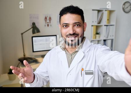 Professioneller Arzt schaut in die Kamera, während er online mit dem Patienten spricht Stockfoto
